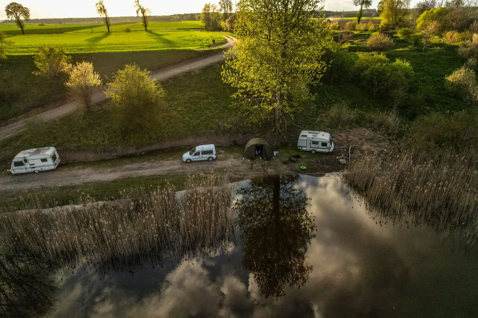Vue aérienne d’un camping au bord d’un lac, avec ses caravanes