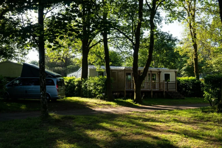 Mobil-home entouré d’arbres dans un camping calme