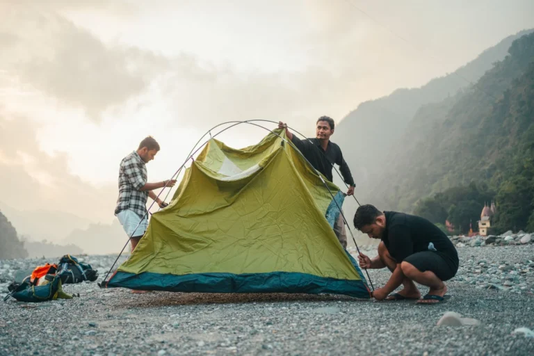 Deux campeurs montent une tente dans un paysage de montagne