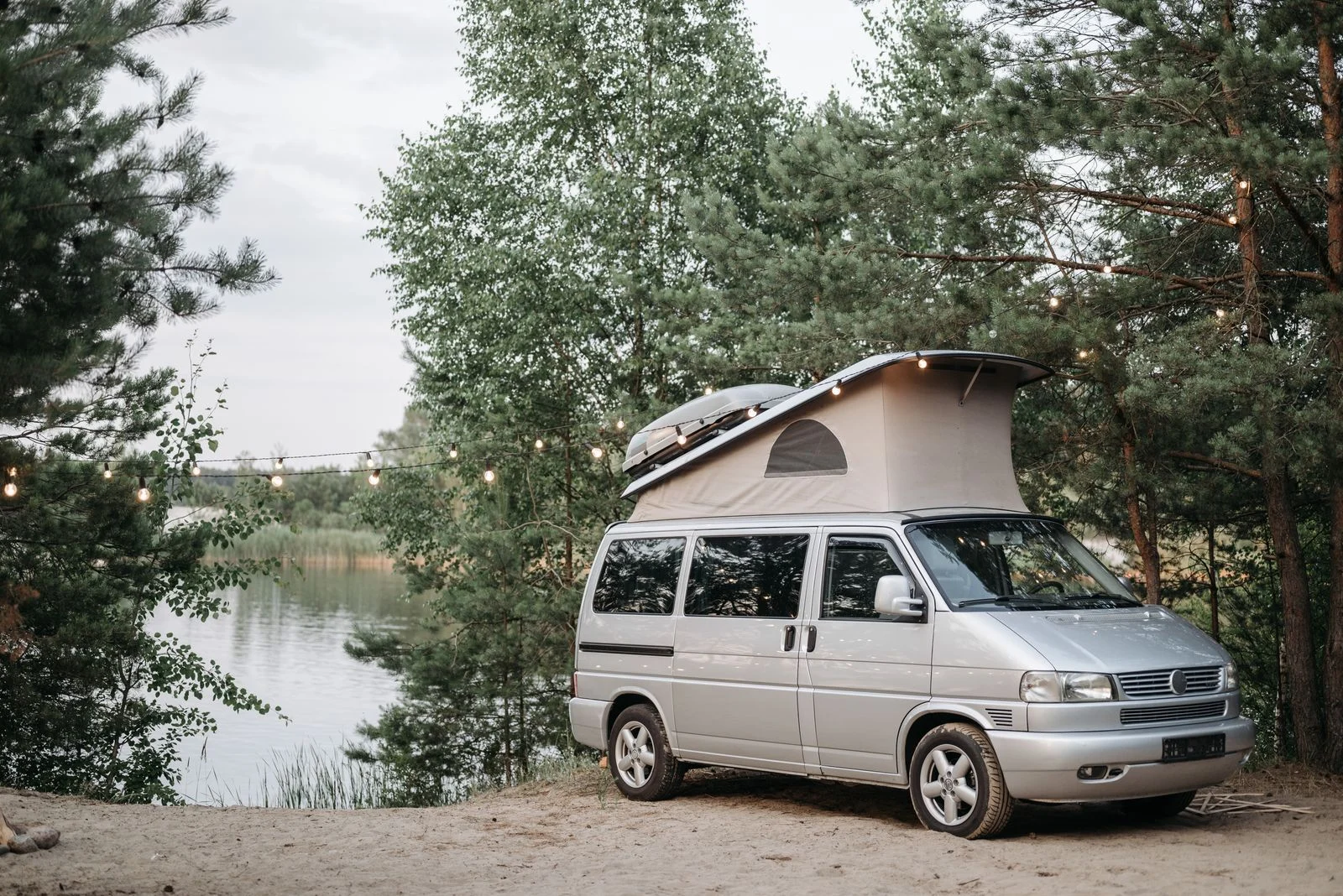 Van aménagé garé sur un emplacement de camping au bord d’un lac